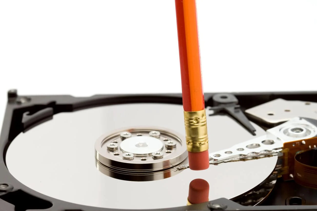 An open hard drive with an eraser resting on the platter